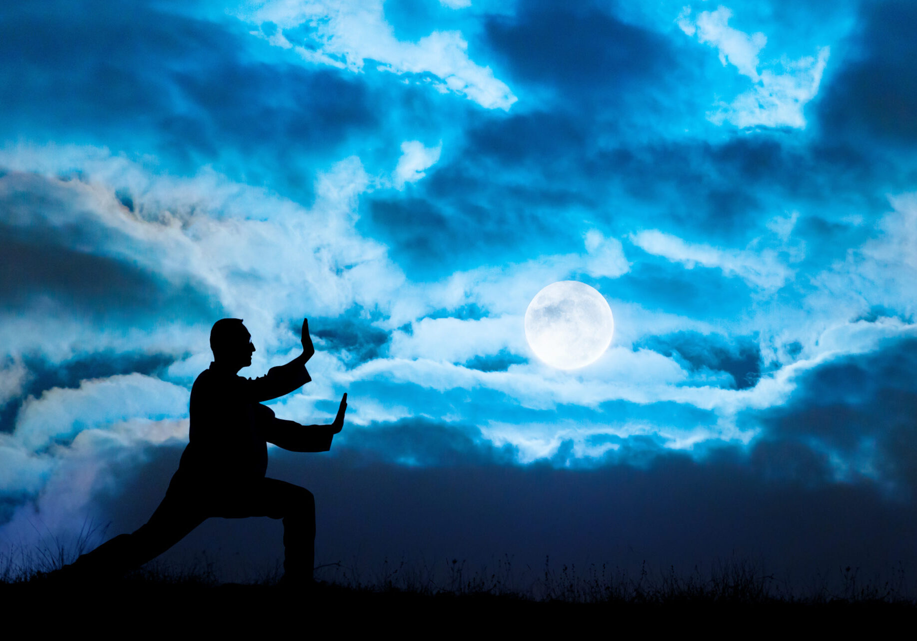 Man performs Tai Chi sport under moonlight. Tai Chi is a old Chinese martial art practiced for both its defense training and its health benefits. Its full name is Tai Chi Chuan. Tai Chi is a meditation sport for many people living in the modern world. It is similar to kung fu; judo; aikido; taekwondo; Yoga; etc.
